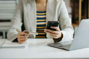 Businesswoman using calculator with credit card for shopping internet online and financial business strategy in office. photo