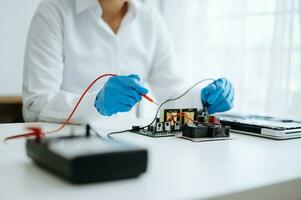 Electronics technician, electronic engineering electronic repair,electronics measuring and testing, repair and maintenance concepts.uses a voltage meter to check and upgrade photo