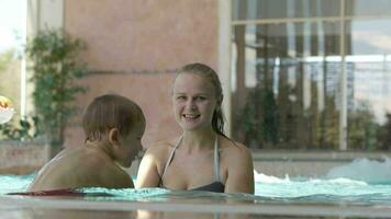 madre y su hijo en el nadando piscina video