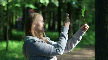 joven mujer tomando un imagen de hoja video