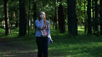 Woman talking on the phone in the park video