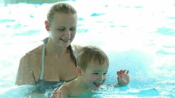 madre y su hijo en el nadando piscina video