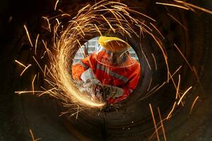 An Electric wheel grinding at Industrial worker cutting metal pipe with many sharp sparks photo