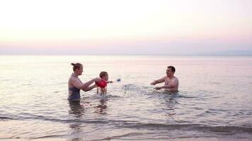 giovane famiglia giocando rosso giocattolo barca a tramonto video
