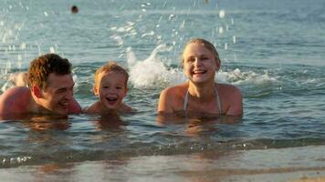 Young family splashing in the sea video