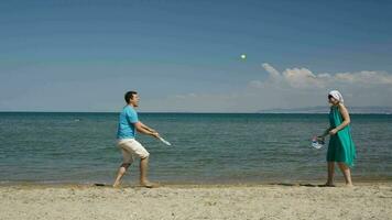 par spelar fladdermus och boll på de strand video