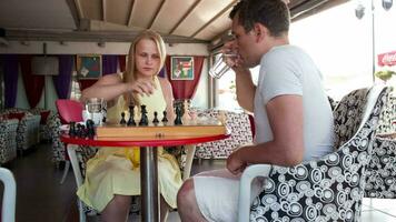 Smiling couple playing a game of chess video