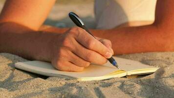 homem escrevendo dentro dele diário às a de praia video