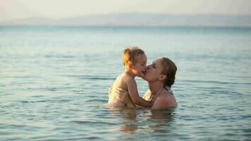 mãe jogando com dela jovem filho dentro a mar video