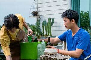 Young handsome asian gay couples are separating households, bottles, cans, trash, paper, egg tray, in front of their house, environment care and global warming concept. photo