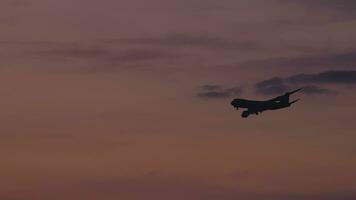 fuselaje ancho avión de carga en el final Acercarse antes de aterrizaje en el antecedentes de el puesta de sol oscuridad cielo video