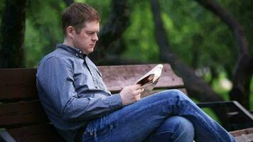 hombre lee periódico en banco en el parque 2 video