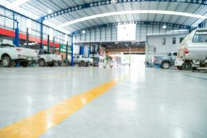 Blurred background of Car repair station paved with epoxy floor and electric lift for a car that comes to change the engine oil in the background of Car repair center with epoxy floors. photo