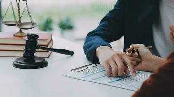 zaken en advocaten bespreken contractpapieren met koperen schaal op bureau in kantoor. wet, juridische diensten, advies, rechtvaardigheid en wet concept foto met film grain effect video