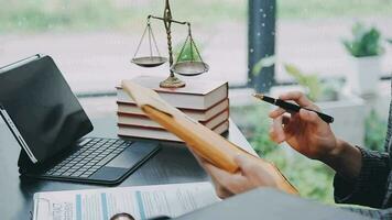 Business and lawyers discussing contract papers with brass scale on desk in office. Law, legal services, advice, justice and law concept picture with film grain effect video