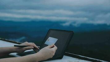 jovem viajante freelancer trabalhando online usando laptop e apreciando a bela paisagem natural com vista para a montanha ao nascer do sol video