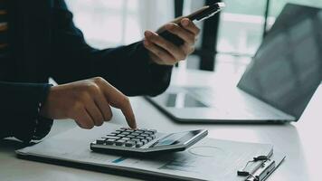 cierre la mano del hombre de negocios usando una calculadora y trabajando con una computadora portátil para calcular la contabilidad financiera en la cafetería outdor.concepto de contabilidad financiera video