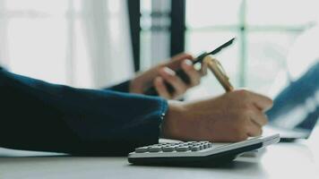 primo piano la mano dell'uomo d'affari utilizzando la calcolatrice e lavorando con il laptop calcolare la contabilità finanziaria al coffeeshop outdor.concetto di contabilità finanziaria video