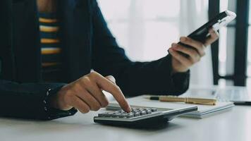 Close up businessman hand using calculator and working with laptop calculate about finance accounting at coffeeshop outdor.finance accounting concept video
