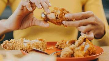 people are eating food, fried chicken together. video