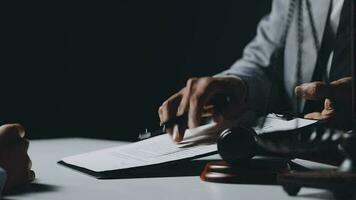 Business and lawyers discussing contract papers with brass scale on desk in office. Law, legal services, advice, justice and law concept picture with film grain effect video