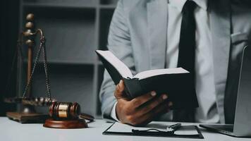 Business and lawyers discussing contract papers with brass scale on desk in office. Law, legal services, advice, justice and law concept picture with film grain effect video