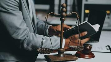 Business and lawyers discussing contract papers with brass scale on desk in office. Law, legal services, advice, justice and law concept picture with film grain effect video