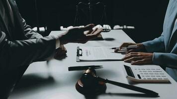 Business and lawyers discussing contract papers with brass scale on desk in office. Law, legal services, advice, justice and law concept picture with film grain effect video