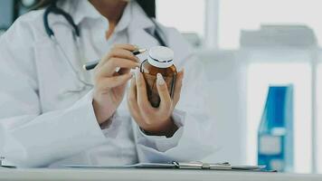 Professional female doctor smiles and shows positive examination results to young, joyful man. Handsome, happy guy with glasses at doctor's appointment in modern office of medical institution. video