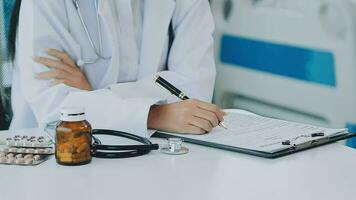 Professional female doctor smiles and shows positive examination results to young, joyful man. Handsome, happy guy with glasses at doctor's appointment in modern office of medical institution. video