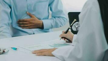 Professional female doctor smiles and shows positive examination results to young, joyful man. Handsome, happy guy with glasses at doctor's appointment in modern office of medical institution. video