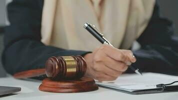 Business and lawyers discussing contract papers with brass scale on desk in office. Law, legal services, advice, justice and law concept picture with film grain effect video