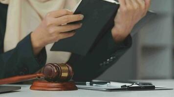 Business and lawyers discussing contract papers with brass scale on desk in office. Law, legal services, advice, justice and law concept picture with film grain effect video