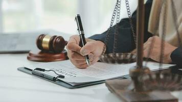 Business and lawyers discussing contract papers with brass scale on desk in office. Law, legal services, advice, justice and law concept picture with film grain effect video