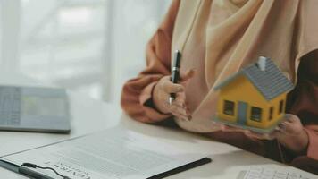 Female woman hands holding home model, small miniature white toy house. Mortgage property insurance dream moving home and real estate concept video