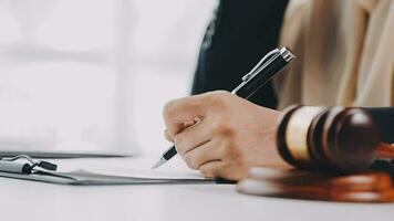 Business and lawyers discussing contract papers with brass scale on desk in office. Law, legal services, advice, justice and law concept picture with film grain effect video