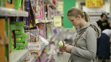 Young woman is choosing toys for her kid video