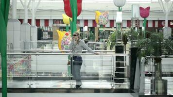 Young woman is talking on the mobile phone in shopping center video