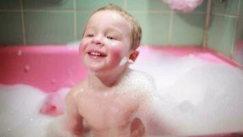 dos año antiguo chico tomando un bañera con espuma lento movimiento video