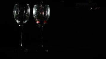 rot Wein ist gegossen in zwei Brille auf schwarz Hintergrund video