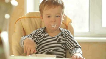 Little boy eats porridge in the morning video