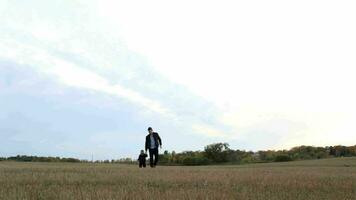 joven padre con su hijo caminando en el campo video