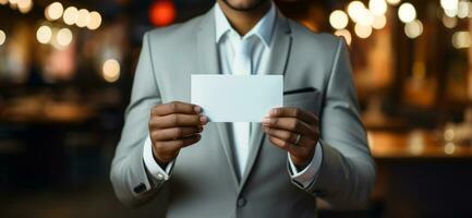 Business man in a suit holds a blank white business card. photo