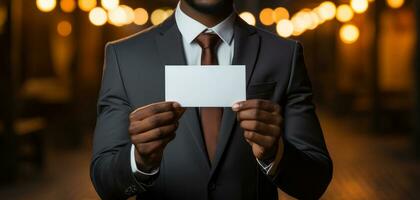 A man in a suit holds a blank white business card photo