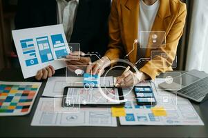 Close up view of UI developer team brainstorming on their project with laptop, smartphone and digital tablet. Creative digital development agency. with virtual icons photo