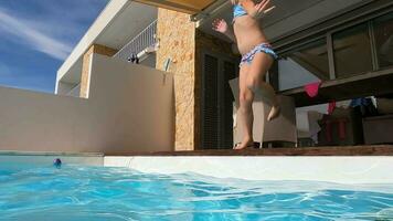 menina saltos para dentro piscina com girar - lento movimento video