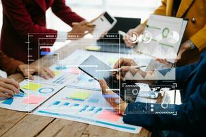 Businessman hand Project manager working and update tasks and Gantt chart scheduling virtual diagram.with smart phone, tablet and laptop in modern office. photo