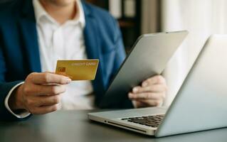 Man using smart phone for mobile payments online shopping,omni channel,sitting on table,virtual icons graphics interface screen photo