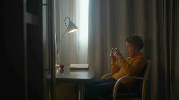 Boy playing on phone at desk video