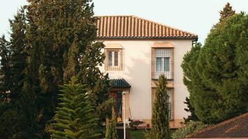 Outside view of two-storey house with pine trees growing nearby video